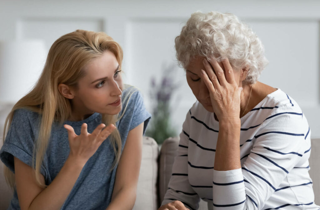 An adult daughter is engaged in a heated discussion with her elderly mother, leaving her mom feeling stressed.
