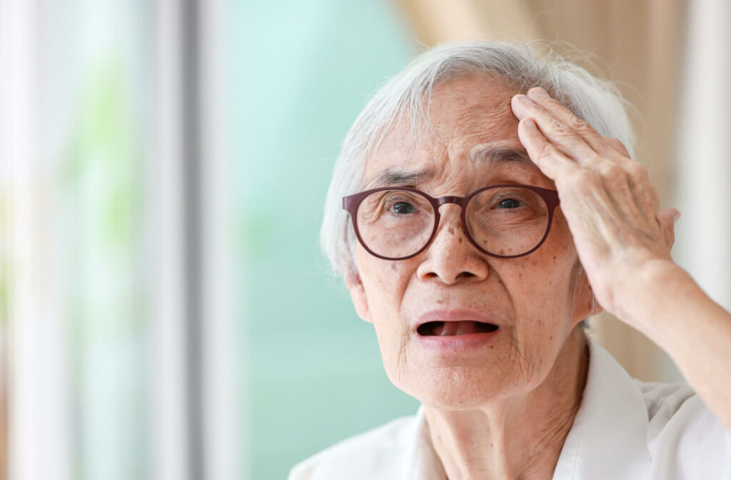 An older adult woman with a look of forgetfulness trying to remember something.