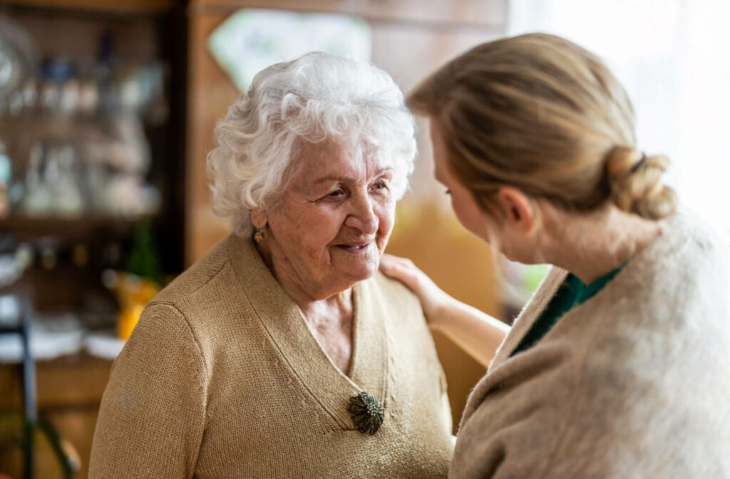 An older adult woman in a senior living facility having a conversation with a nurse.